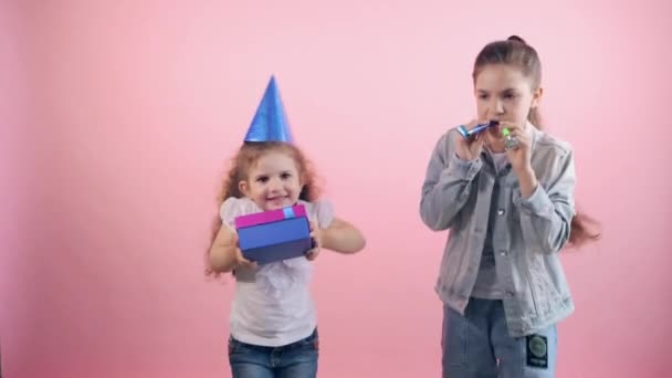 Fête d'anniversaire avec casquettes, cadeaux. Fille satisfaite avec un cadeau dans ses mains. — Video