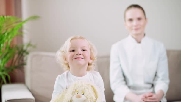 Beau bébé blond au premier plan avec un jouet à la main. — Video