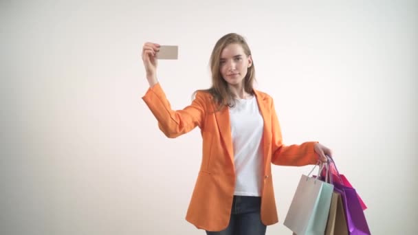 Heureuse fille satisfaite fait des achats à un grand escompte. Carte dans les mains. — Video