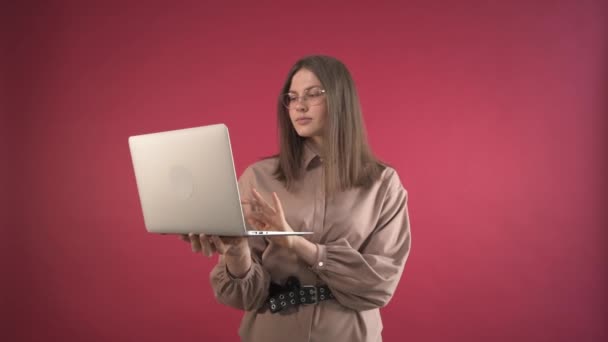 La joven empresaria está trabajando sosteniendo un portátil en sus manos. Mujer con gafas — Vídeos de Stock