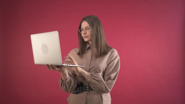 Flickan håller en bärbar dator i händerna och ser med missnöje på skärmen. — Stockvideo
