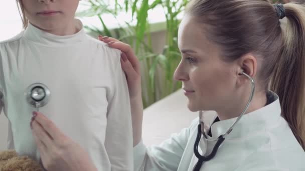 Close up of a female doctor listening to baby lungs with a phonendoscope. — Stock Video