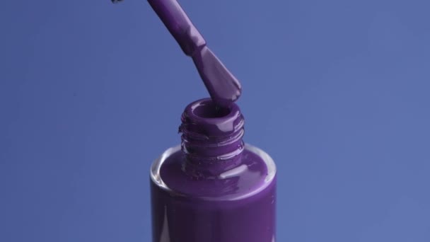 Відкрита баночка лаку для нігтів. Фіолетовий колір лаку . — стокове відео