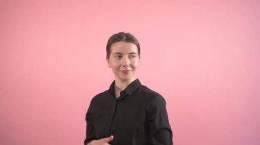 Tatmin olmuş güzel bir kadın başparmak işareti yapıyor ve kameraya bakıyor..