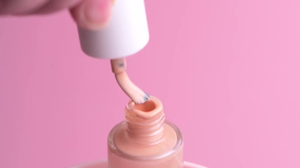 漂亮精致的粉色指甲油.用刷子刷一下罐子的脖子. — 图库视频影像