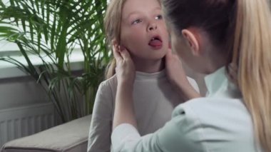 Aile doktoru hastasının evine geldi ve çocuğun boğazına bakıyor..