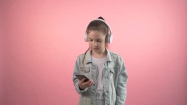 Şirin kız kulaklıkla müzik dinliyor ve dans ediyor. Güzel müzik.