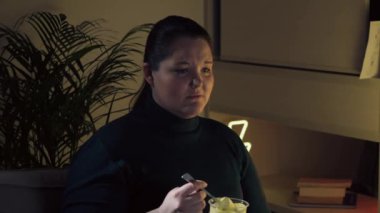 Üzgün kız televizyon izliyor ve tatlı dondurma yiyor. Melodram izliyorum. 4K video