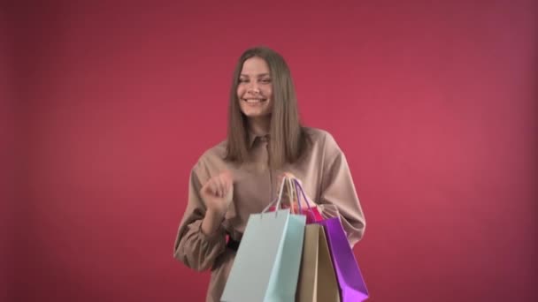 Młoda dziewczyna chodzi po sklepie z zakupami, cieszy się udanymi zakupami. — Wideo stockowe