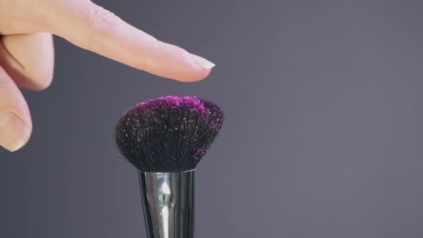 Belle vidéo lumineuse d'un pinceau cosmétique. Beaucoup de paillettes brillantes coulent sur le dessus — Video