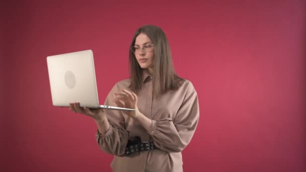 Una chica con una cara disgustada mira un monitor de computadora portátil. Chica dama de negocios . — Vídeos de Stock