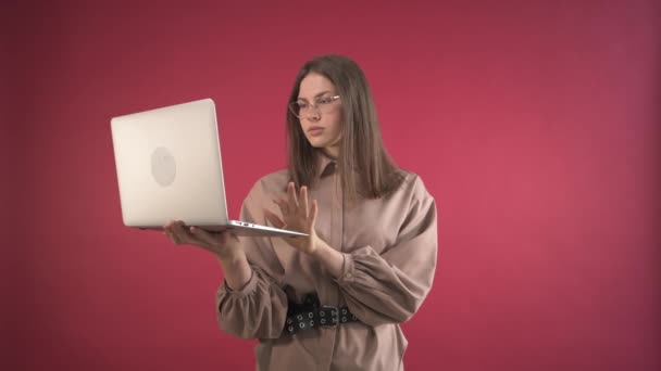 La fille regarde l'ordinateur portable et rit. Loisirs après une journée de travail. — Video