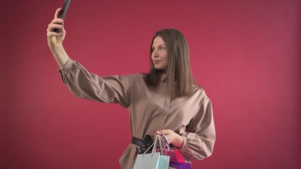 Irl loopt door de winkel met aankopen en neemt een selfie. Blogger meisje. — Stockvideo