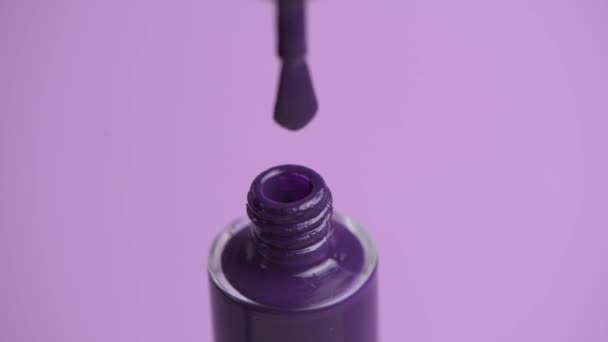 Close up of open nail polish. A drop of varnish is dripping from the brush. — Stock Video