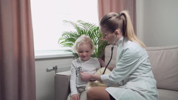En läkare i vit rock lyssnar på babys lungor med fonoskop.. — Stockvideo