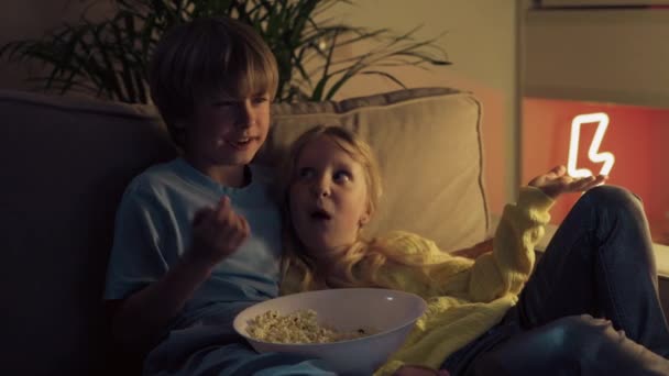 Hermano y hermana viendo la televisión y hablando. Hermano abrazó a su hermana menor . — Vídeos de Stock