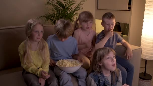 П'ять милих дітей дивитися мультфільм по телевізору вночі, радіти, сміятися і отримувати задоволення . — стокове відео