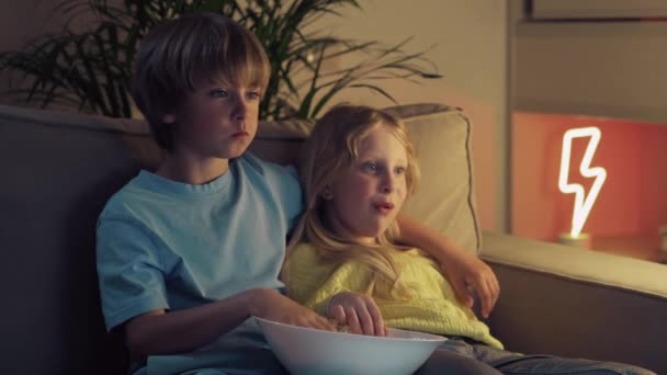Niño y niña viendo dibujos animados y sonriendo. El concepto de entretenimiento, familia . — Vídeos de Stock