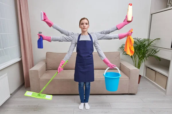 Holka s mnoha rukama uklízí dům. Multitasking koncept manželky v domácnosti. — Stock fotografie