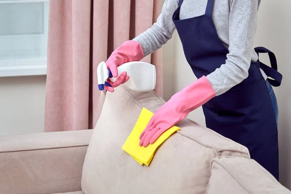 A menina de luvas de borracha varre o detergente na mobília. Sem rosto. . — Fotografia de Stock