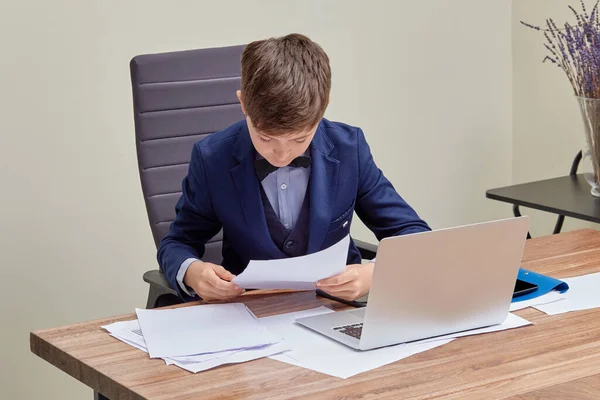Geschäftsmann sitzt im Büro am Tisch und liest, was in Dokumenten steht. — Stockfoto