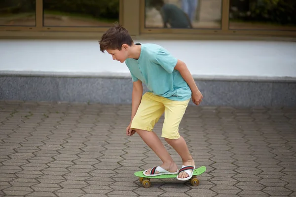 Hezký mladý kluk teenager jezdí na skateboardu. Zaměření na nohy a skateboard. — Stock fotografie