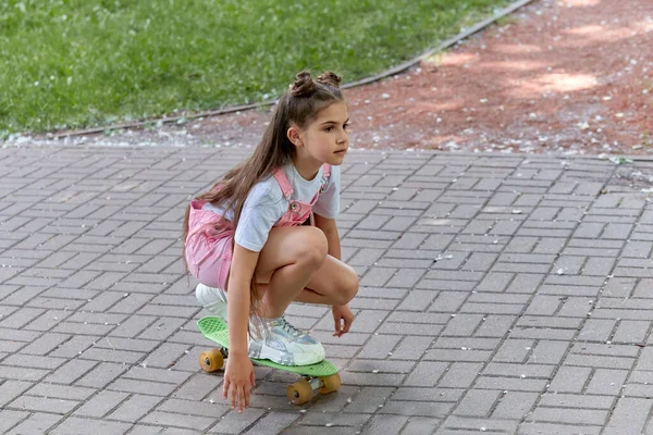 Menina morena bonita monta uma placa no parque. Estilo de vida desportivo Férias de verão . — Fotografia de Stock