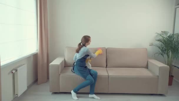 한 소녀는 가벼운 소파에서 더러운 얼룩을 씻는다. 집안 청소. — 비디오