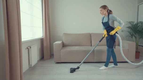 若い美しい少女は床を掃除します。日常生活. — ストック動画