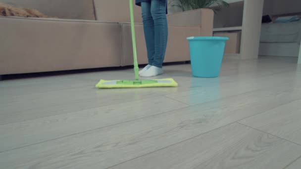 Primer plano del piso de limpieza en la sala de estar. Hay un cubo con agua cerca . — Vídeos de Stock