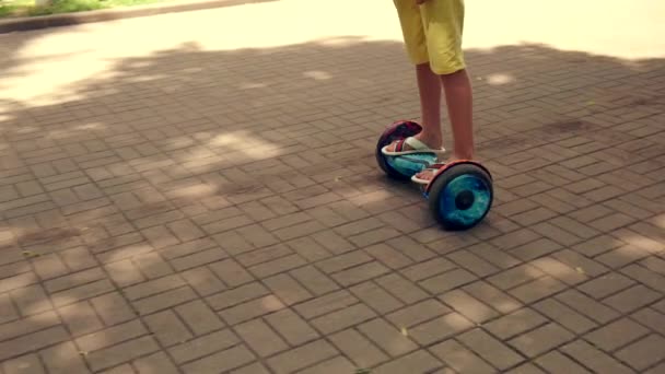 Montando um hoverboard com luzes em um parque de verão. Lazer . — Vídeo de Stock