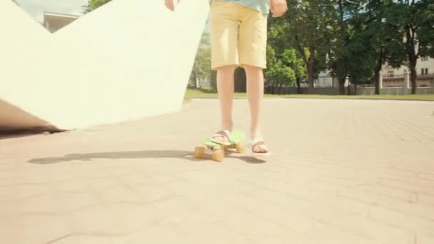 머리좋은 갈색 머리 남자가 시내에서 스케이트보드를 타고 있어요. 태양이 내리는 날씨. — 비디오