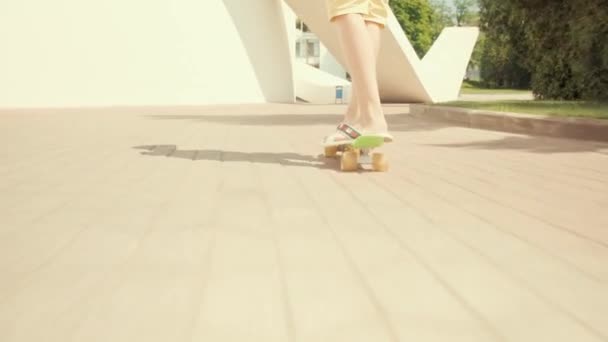 Pohled zezadu na chlapce na skateboardu ve městě. Slunečné počasí. — Stock video
