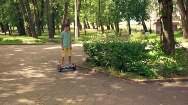 Auf einem Hoverboard reiten und Stunts im Sommerpark vorführen. Sommerferien. — Stockvideo