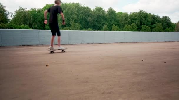 Un bel enfant fait du skateboard et profite du beau temps. — Video