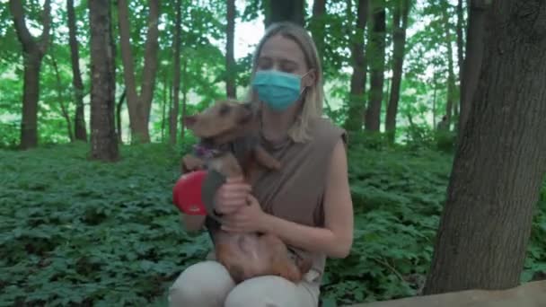 Девушка сидит с собакой на руках. Собака любит своего хозяина и лижет её лицо. 4k — стоковое видео