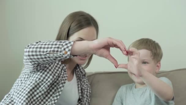 Uma bela jovem mãe e seu filho fizeram um gesto de amor juntos. 4k — Vídeo de Stock