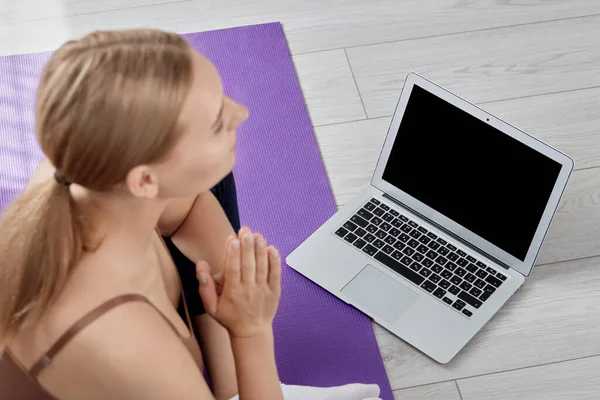 A menina está se preparando para uma aula de ioga. Concentra-te no portátil. A rapariga está turva. . — Fotografia de Stock
