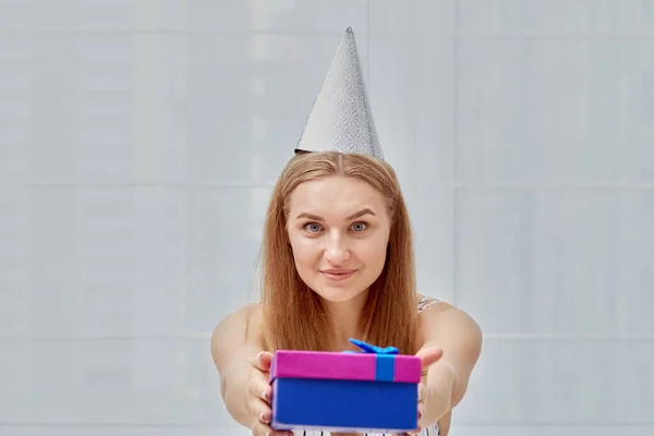 Giovane bella ragazza bionda per il suo compleanno. Donna in un berretto festivo. — Foto Stock