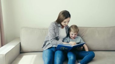 Genç, güzel anne ve çocuk birlikte kitap okuyorlar.