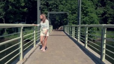 Gülümseyen mutlu kadın nehir ve ormanın manzarasının tadını çıkarıyor. 4K