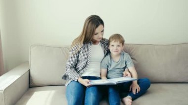 Okul için hazırlık. Genç güzel anne ve bebek birlikte kitap okuyorlar..