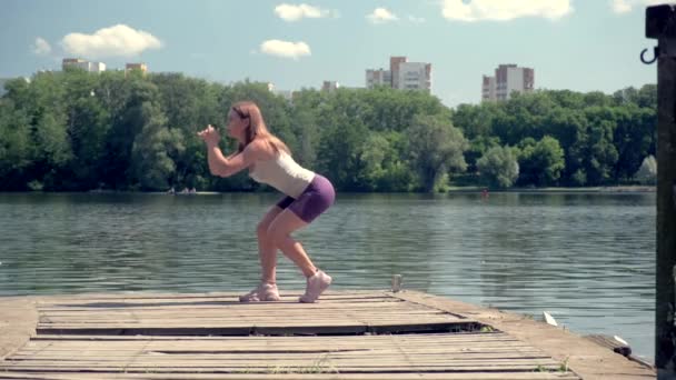 Το κορίτσι έχει αθλητικό σώμα. Η γυναίκα κάνει ασκήσεις για το αθλητικό σώμα.. — Αρχείο Βίντεο