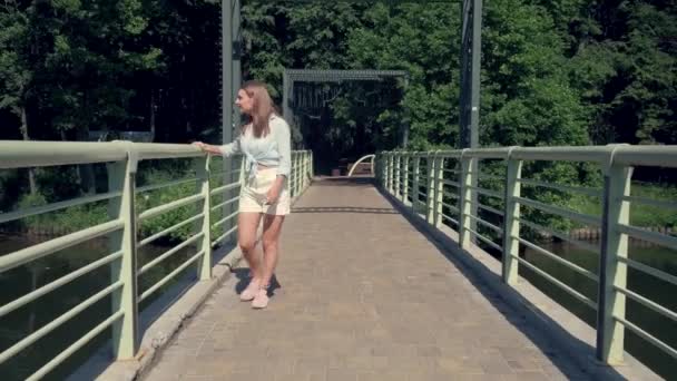 Sorrindo mulher feliz andando e apreciando a vista do rio e da floresta. 4K — Vídeo de Stock