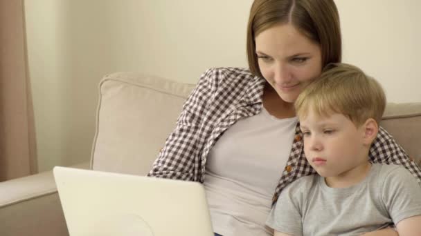 Belle jeune fille maman regarder attentivement le film éducatif ensemble. 4k — Video