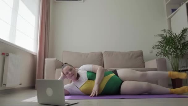Una hermosa joven morena entra a hacer deporte y se estira. — Vídeos de Stock