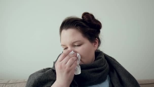Una joven morena enfermó de un resfriado. Una bufanda caliente alrededor del cuello. — Vídeo de stock