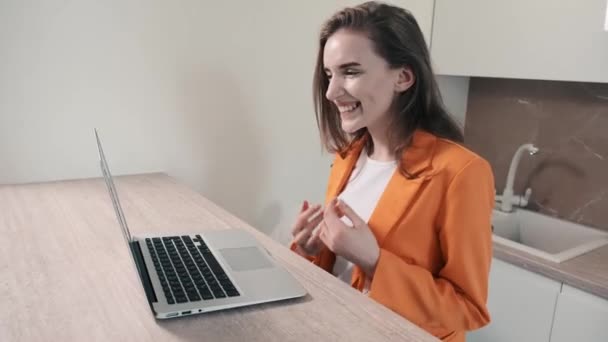 행복 한 소녀가 집에 앉아서 온라인으로 영상 통화를 합니다. 4k 비디오. — 비디오