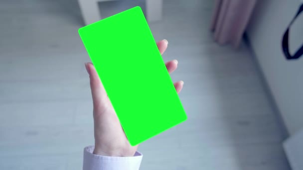 Una mano femenina sostiene una mesa rectangular verde, en blanco para la publicidad. — Vídeos de Stock