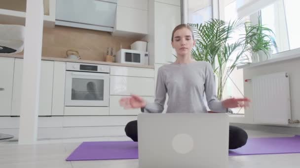 Spor giyim sektöründe bir kadın yerde oturup yoga yapıyor.. — Stok video